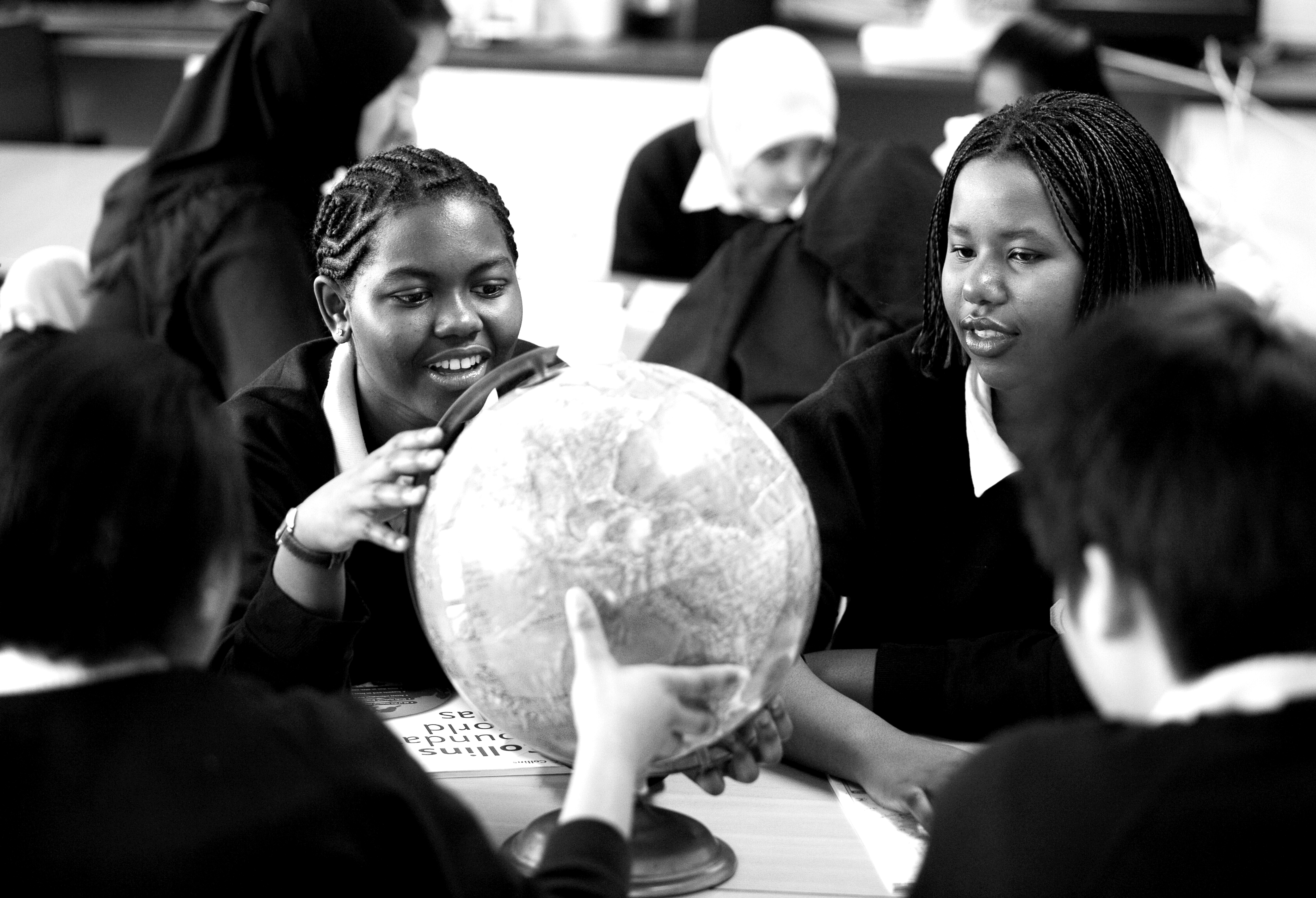 A group of four secondary school students using a globe.