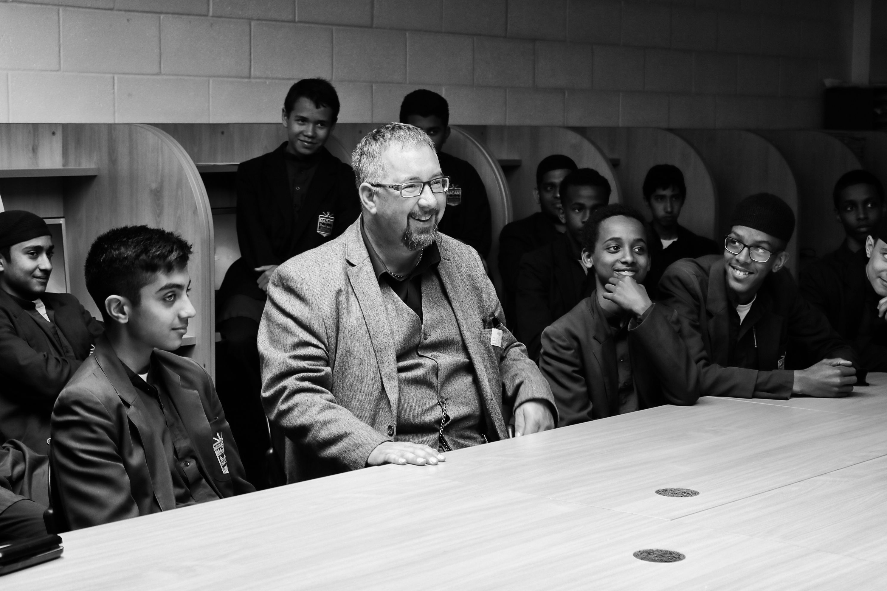 A group of students at a table listening to Mike Haines speak